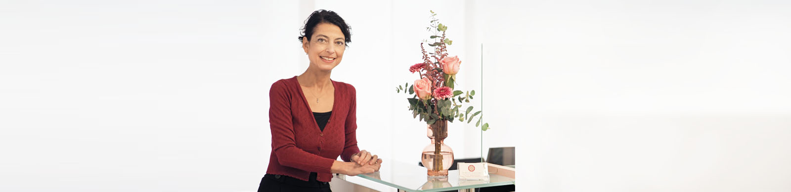 Frau Dr. Elif Çalışkan-Erle an der Empfangstheke mit Blumen