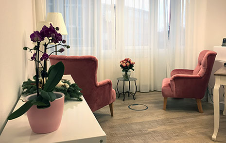 Psychotherapie-Raum: 2 Sessel in Altrose, dazwischen ein kleiner Tisch mit Rosenstrauß